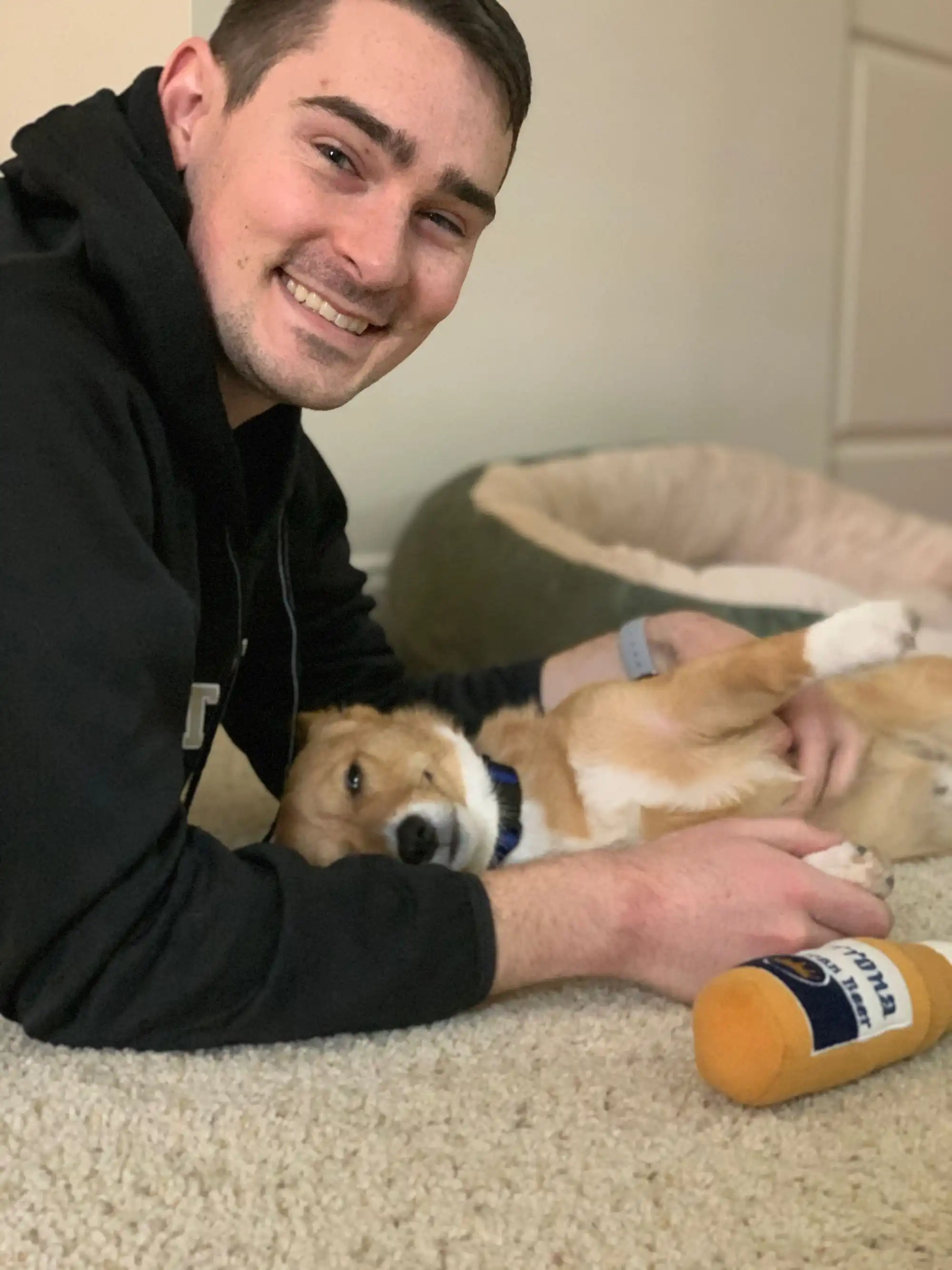 Man smiling with peaceful corgi.